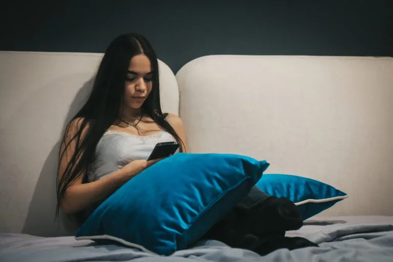 Brunette girl texting in the bed